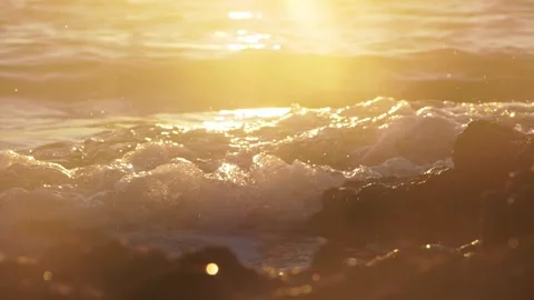 Bright golden sunset light reflecting on crashing ocean foam waves Stock Footage 337409106