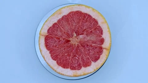 A bright grapefruit half is spinning. 스톡 동영상 331032582