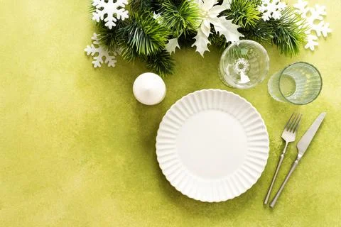 A bright green Christmas table setting with an empty plate and cutlery. The.. Stock Photos