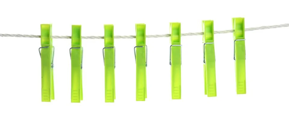 Bright green plastic clothespins hanging on rope against white background Stock Photos
