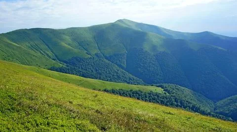 Bright green slopes of the mountain range. mountain landscape. tourist tents Stock Photos
