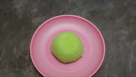 Bright green steamed bread on a pink plate Stock Footage 323579607