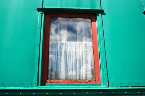 Bright green window with a delicate white curtain under a clear sky 스톡 사진
