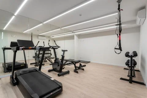 Bright gym features several types of workout machines including a treadmill Stock Photos