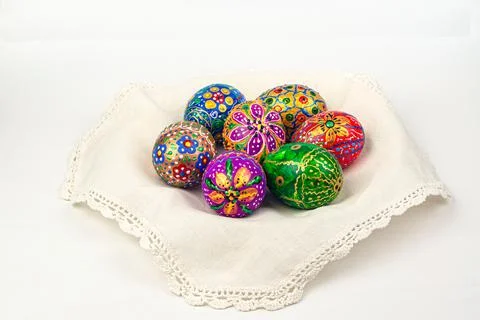 Bright hand-painted Easter eggs on a white embroidered napkin Stock Photos