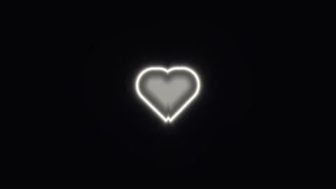 Bright heart shape glowing against a dark background at Stock Footage 338040127