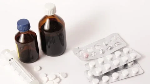 Bright high quality studio shot with pan of pills, syringe and medicine bot.. Stock Footage 233432852