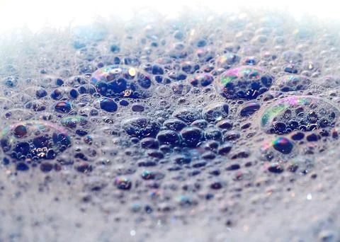 Bright highlights on the surface of foam bubbles on the liquid Stock Photos