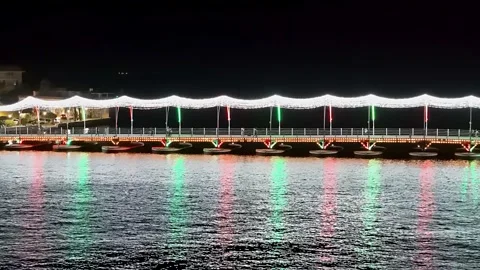 Bright holiday string lights reflect and shimmer on water from pontoon Stock Footage 263887517