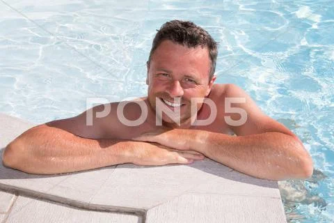 Bright image of a handsome man in the pool Stock Photos