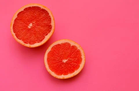 Bright image slice of red grapefruit on a pink background close up Stock Photos