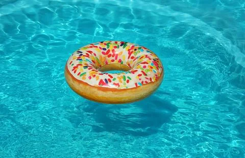 Bright inflatable doughnut ring floating in swimming pool on sunny day 写真素材