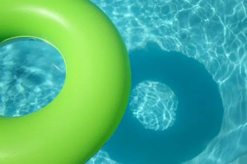 Bright inflatable ring floating in swimming pool on sunny day. Space for text 스톡 사진