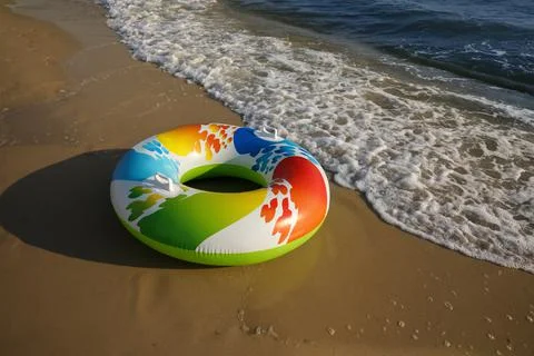 Bright inflatable ring on sandy beach near sea, space for text 스톡 사진