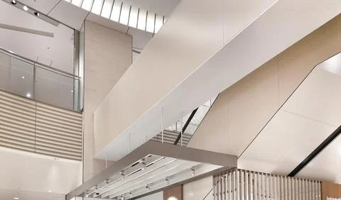 A bright interior featuring clean lines, angular white ceilings, glass railin Stock Photos