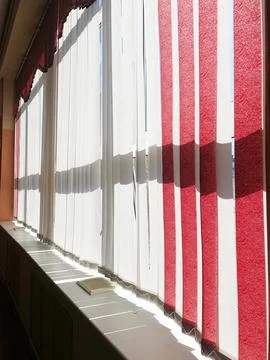 Bright interior featuring vertical blinds on large windows, allowing natural Stock-Fotos