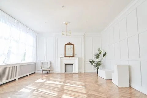 Bright interior with large windows and a fireplace in a classic style. Large Foto stock