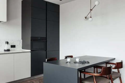 Bright kitchen with dark table, convenient location of kitchen accessories and Stock Photos