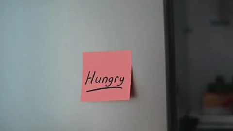 A bright kitchen shows a sticky note with the word hungry written on it. The Stock Footage 339096417
