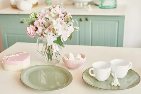 Bright kitchen in the style of Provence, on the table dishes and a bouquet of fl Stock Photos