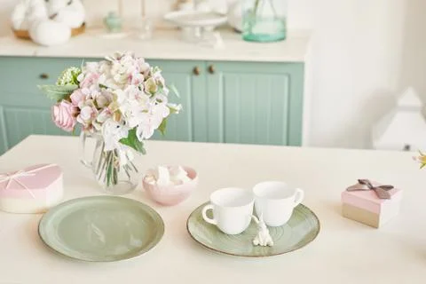 Bright kitchen in the style of Provence, on the table dishes and a bouquet of fl Stock Photos