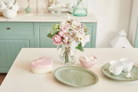 Bright kitchen in the style of Provence, on the table dishes and a bouquet of fl Stock Photos