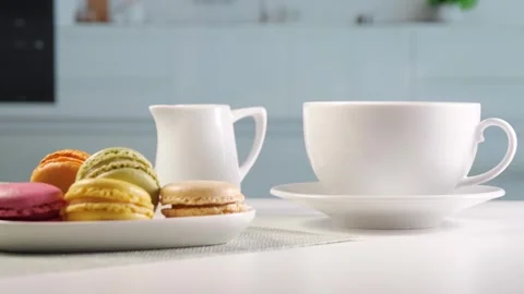 Bright kitchen, on the table there is coffee with a milk jug and a plate with Stock Footage 258706515