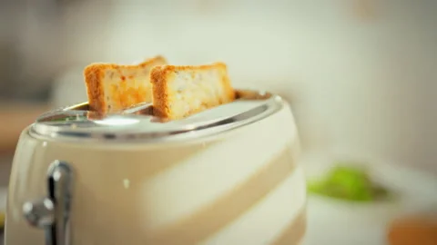 In a bright kitchen a vintage toaster pops up golden toast the sliced bread Stock Footage 336570850