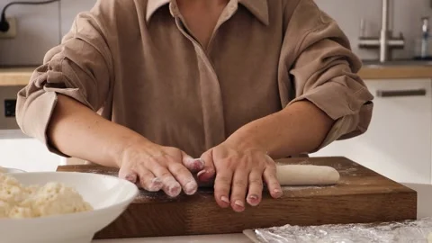 In a bright kitchen, a woman skillfully prepares curdies Stock Footage 316768834