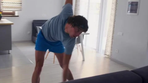 Bright kitchen workout with dumbbell, Home exercise focusing on rotation and Stock Footage 331280444