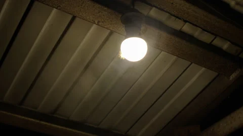 Bright LED lamp light with yellow light on street under iron roof, there smoke Vidéo 219523519