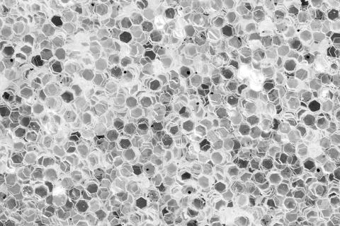 Bright light background with dark spangles on macro. Stock Photos