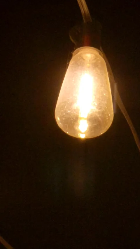 Bright Light Bulb Glowing in the Dark Background Stock Footage 338045114