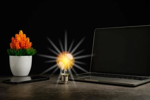 A bright light bulb on work table. Concept of a startup that drives the eco.. Stock Photos