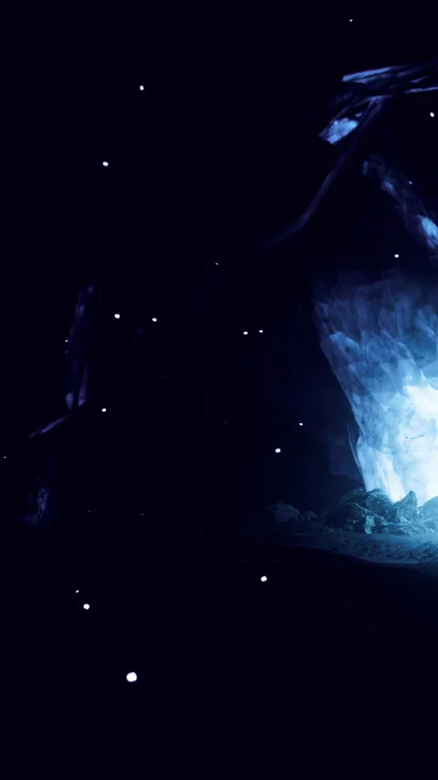 Bright light glows in dark cave with glimmering specks in the background Stock Footage 331368122