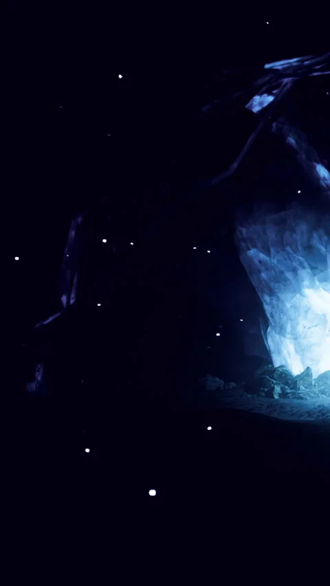 Bright light glows in dark cave with glimmering specks in the background Stock Footage 332205444