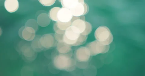 Bright light patterns shimmer on green ocean surface during summer daylight Stock Footage 344753170