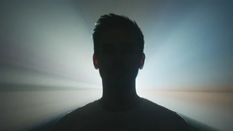 Bright light projected behind a man Stockbeeldmateriaal 216493363
