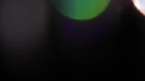 Bright light shines in the blackness as a large multi-colored bokeh. Stock Footage 319378656