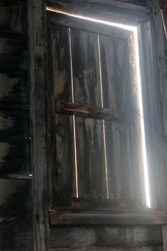 Bright Light Shining Through Old Rustic Wooden Window Shutter 库存照片