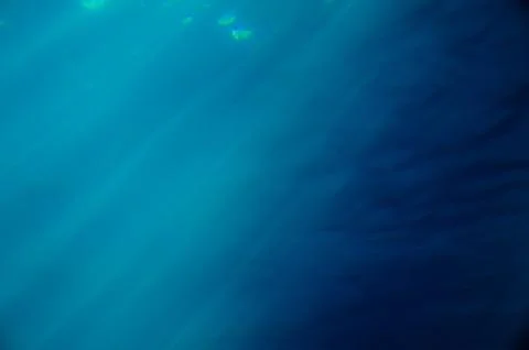 Bright light shinning down in the blue ocean Stock Photos