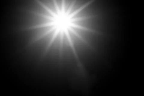 Bright light source emitting radiant beams on a dark background Stock Photos