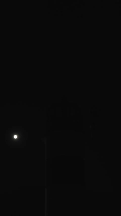 Bright lighthouse guides ships through the night at tranquil shore vertical Stock Footage 296011856