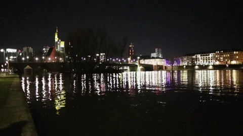 Bright lighting of the night city is reflected in the black water of the river Stock Footage 130371403