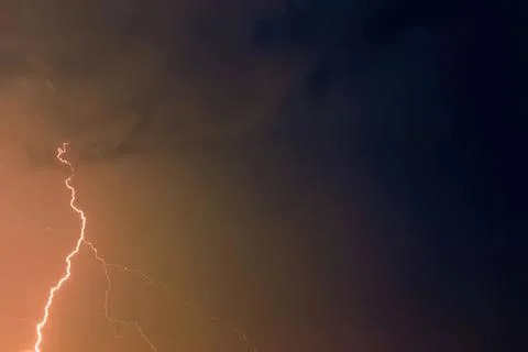 Bright lightning bolt in a dark stormy sky at night Stock Photos