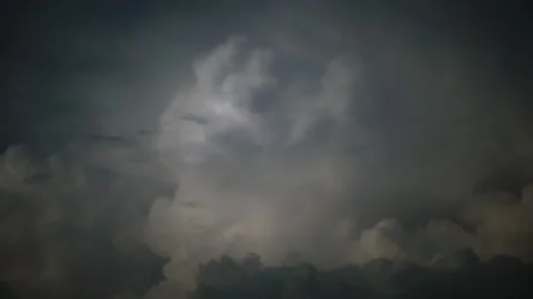 A bright lightning flash cuts across heavy storm clouds at night. Thunderstorm. Stock Footage 323462922