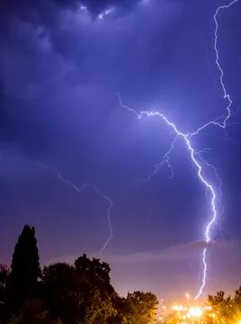 Bright lightning sparkles with a beautiful pattern in the evening sky over the Stock Photos
