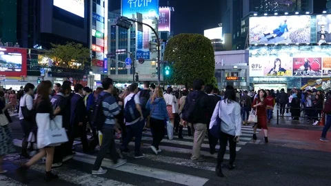 Bright lights at busy Shibuya intersection, many asian people cross road, Tokyo Stock Footage 97954310