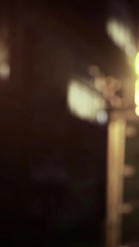 Bright lights shine on tall building in urban area at night Stock Footage 334175384