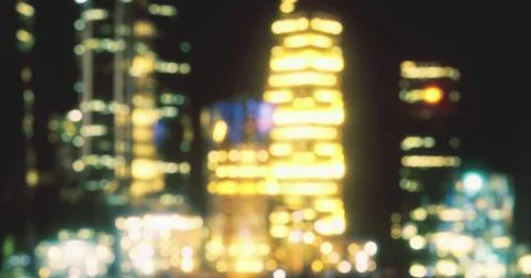 Bright lights from tall buildings create a colorful urban skyline at night Ilustración de archivo